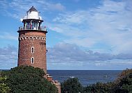 Leuchtturm in Kolberg vor blauem Himmel und Meer