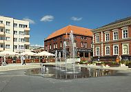 , Lebhafter Platz in Swinemünde mit Springbrunnen und Cafés., Brunnen und historische Gebäude im Zentrum von Swinemünde.
