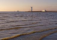 , Leuchtturm Swinemünde bei Sonnenuntergang, ruhige Ostseewellen., Leuchtturm in Swinemünde bei Sonnenuntergang am Meer.