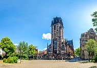 Duisburg, Duisburger Salvatorkirche bei klarem Himmel, umgeben von Grün.