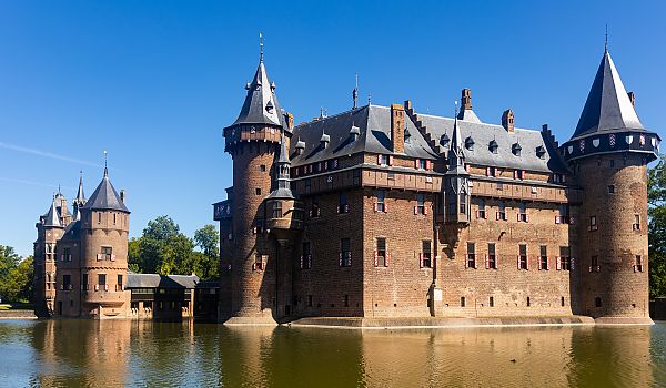 Utrecht, Schloss De Haar in Utrecht bei strahlend blauem Himmel., Schloss de Haar in Utrecht, majestätisch am Wasser gelegen.