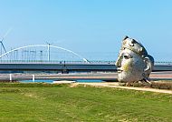 Gesicht von Nijmegen vor moderner Brücke und Windrädern.