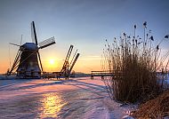 Windmühle, Windmühle im Sonnenuntergang, winterliche Landschaft in den Niederlanden.