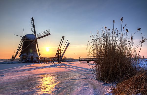 Windmühle, Windmühle im Sonnenuntergang, winterliche Landschaft in den Niederlanden.