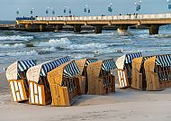 Strandkörbe am Meer mit Seebrücke in Kolberg bei Sonnenuntergang