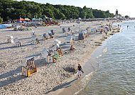 Sonniger Strand in Kolberg mit Strandkörben und Leuchtturm