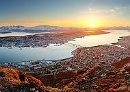 Sonnenuntergang über Tromsø mit Fjord und Bergen im Hintergrund.