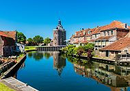 , Kanal in Enkhuizen mit historischem Turm und malerischen Häusern., Idyllischer Kanal in Enkhuizen am Ijsselmeer.