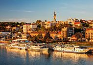 Panorama von Belgrad bei Sonnenuntergang mit Schiffen an der Donau.