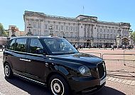 , Schwarzes London Taxi vor dem Buckingham Palace bei Sonnenschein.
