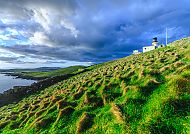 Lerwick, Shetlandinseln, Leuchtturm auf grüner Klippe unter dramatischem Himmel, Lerwick.