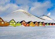 Longyearbyen, Bunte Häuser vor schneebedeckten Bergen in Longyearbyen, Spitzbergen.