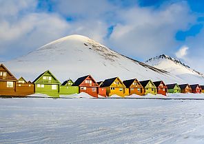 Longyearbyen, Bunte Häuser vor schneebedeckten Bergen in Longyearbyen, Spitzbergen.