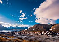 Longyearbyen, Longyearbyen unter blauem Himmel, umgeben von majestätischen Bergen., Longyearbyen unter blauem Himmel, umgeben von Bergen und Fjorden.