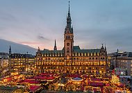 Hamburg, Weihnachtsmarkt vor dem Hamburger Rathaus bei Abenddämmerung.
