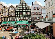 Auf dem Clubschiff den Rhein entdecken, Idyllischer Marktplatz mit Fachwerkhäusern und lebhaftem Treiben., Malerischer Platz mit Fachwerkhäusern und lebhaftem Treiben.