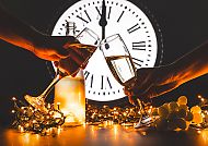 Silvester, Silvesterfeier mit Sekt und Lichterketten vor Uhr.