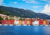 Bergen (Route 1 & 2), Bunte Häuser am Hafen von Bergen vor malerischer Bergkulisse., Bunte Häuserreihe in Bergen vor majestätischer Bergkulisse.