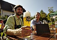 , Geselliges Beisammensein bei sonnigem Biergartenwetter., Gemütlicher Biergenuss im sonnigen Biergarten.