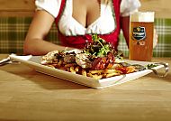 , Herzhaftes Essen und kühles Bier in gemütlicher Atmosphäre., Bayerische Gemütlichkeit mit Bier und herzhaftem Essen genießen.