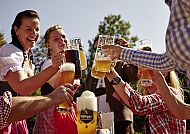 , Fröhliche Runde beim Biergenuss im Freien. Wohlgefühl & Hopfenglück., Fröhliche Biergartenrunde bei strahlendem Sonnenschein.