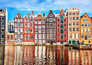 , Bunte Grachtenhäuser in Amsterdam spiegeln sich im Wasser., Bunte Grachtenhäuser in Amsterdam spiegeln sich im Wasser.