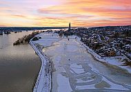 , Winterlicher Sonnenuntergang über Arnheim mit vereister Landschaft., Winterliche Flusslandschaft in Arnheim bei Sonnenuntergang.