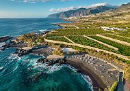 Küstenlandschaft von Teneriffa mit Bergen und schwarzem Sandstrand.
