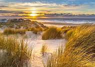 , Sonnenuntergang am Strand von Texel mit goldenen Dünen.