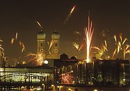 Silvesterfeuerwerk über München, Silvesterfeuerwerk über München mit Frauenkirche im Hintergrund., Silvesterfeuerwerk über München bei Nacht, festliche Atmosphäre.
