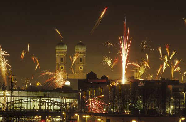 Silvesterfeuerwerk über München, Silvesterfeuerwerk über München mit Frauenkirche im Hintergrund., Silvesterfeuerwerk über München bei Nacht, festliche Atmosphäre.