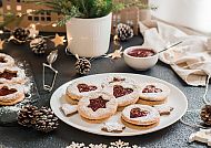 , Weihnachtliche Plätzchen mit Marmelade und Tannenzapfen-Dekor.