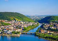 , Idyllische Rheinlandschaft mit malerischer Stadt und Fluss., Malerische Rheinlandschaft mit Stadt und Fluss im Sonnenschein.