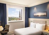 Zimmerbeispiel Vorprogramm, Modernes Hotelzimmer mit Blick auf Kieler Kirchturm., Modernes Hotelzimmer mit Blick auf Kiels Kirchturm.