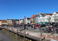 Husum, Bunte Häuserfassade am Hafen von Husum bei strahlend blauem Himmel., Bunte Häuserzeile am Hafen von Husum bei strahlend blauem Himmel.