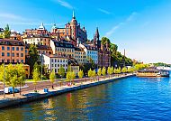 Stockholm, Bunte Gebäude am Wasser in Stockholm bei sonnigem Wetter., Stockholms malerische Küste mit bunten Gebäuden und blauem Wasser.