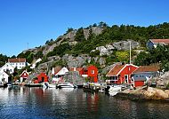 Kristiansand, Idyllische Küstenlandschaft in Kristiansand, Norwegen., Bunte Küstenhäuser in Kristiansand vor felsiger Landschaft.
