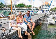 Fischbrötchen am Hafen genießen, Familie genießt Fischbrötchen am sonnigen Hafen von Usedom.