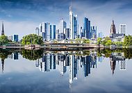 Frankfurts Skyline spiegelt sich im Main, klare Himmel und Wolkenkratzer.