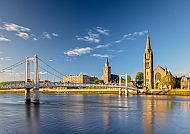 Ausflugstipp: Inverness, Inverness am Fluss mit Brücke und Kirchturm bei Sonnenschein., Inverness: Malerische Stadtansicht mit Brücke und Kirche.
