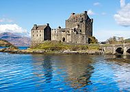Ausflugstipp schottische Highlands, Eilean Donan Castle in den schottischen Highlands bei Sonnenschein., Eilean Donan Castle in den schottischen Highlands am Wasser.