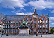 Düsseldorfer Rathaus mit Reiterstatue vor blauem Himmel.