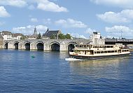 Schiff auf der Maas vor der historischen Brücke in Maastricht.