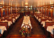Elegantes Restaurant auf einem Schiff mit festlich gedeckten Tischen.