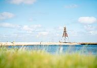Die Kugelbake in Cuxhaven am blauen Nordseestrand, eingerahmt von weichem Dünengras.