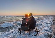 Sylt Paar im Winter auf einem Schlitten