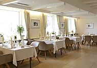 Elegantes Hotelrestaurant mit gedeckten Tischen und heller Atmosphäre.