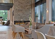 Moderne Hotelhalle mit gemütlichem Kamin und eleganten Sitzmöbeln.