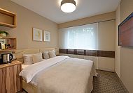 Gemütliches Doppelzimmer mit Bett, TV und moderner Einrichtung.