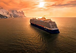 Kreuzfahrtschiff bei Sonnenuntergang auf ruhiger See.